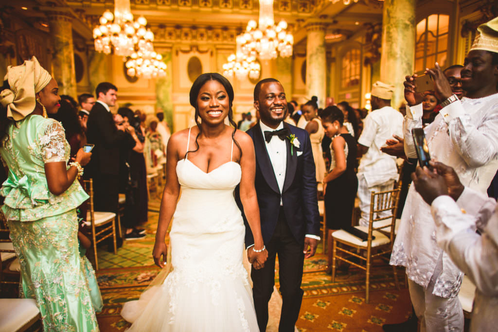 black couple walking down the aisle after wedding ceremony