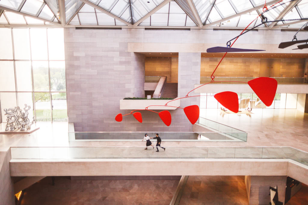 couple running through museum hand in hand